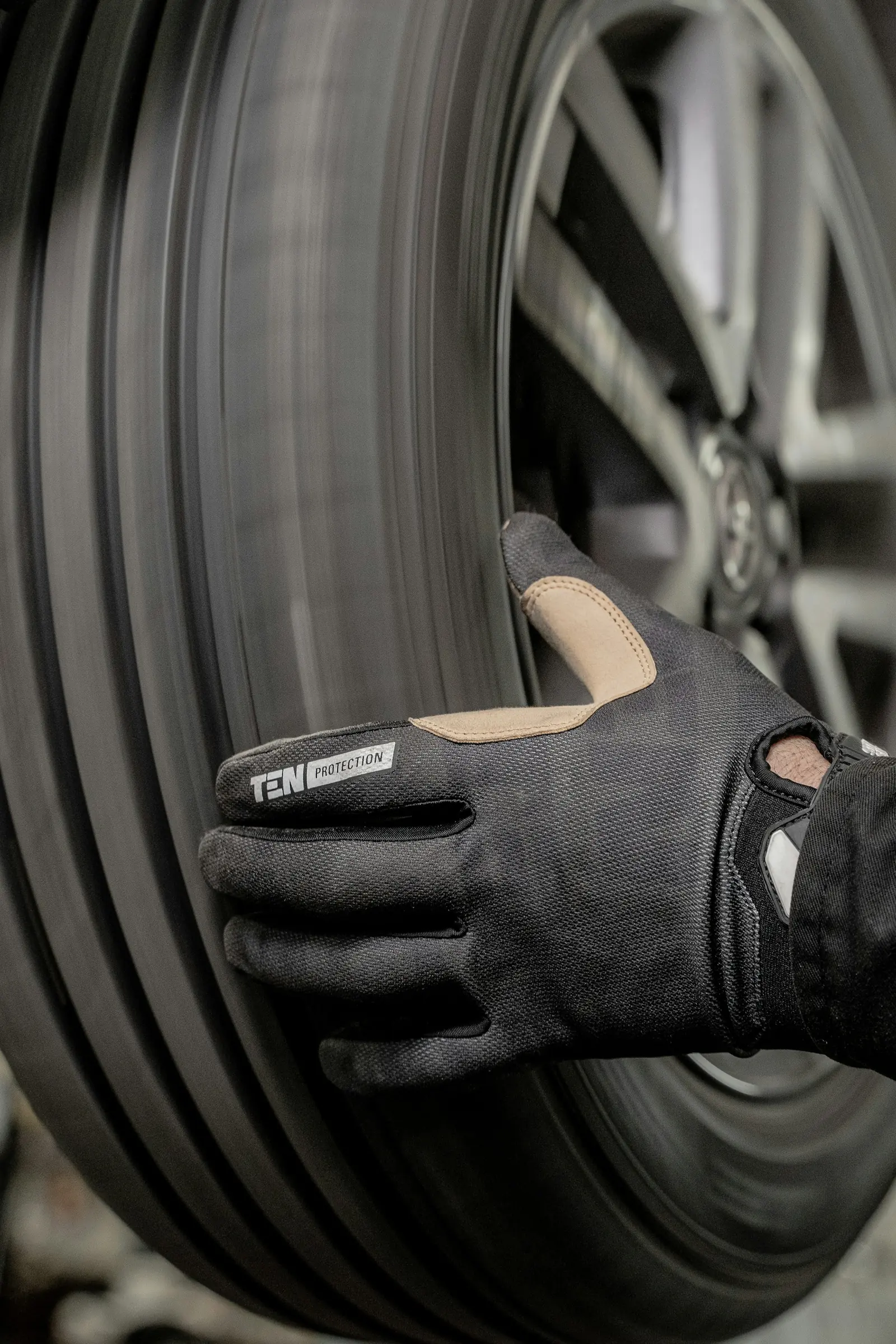 Close-up of a gloved mechanic's hand on a tire